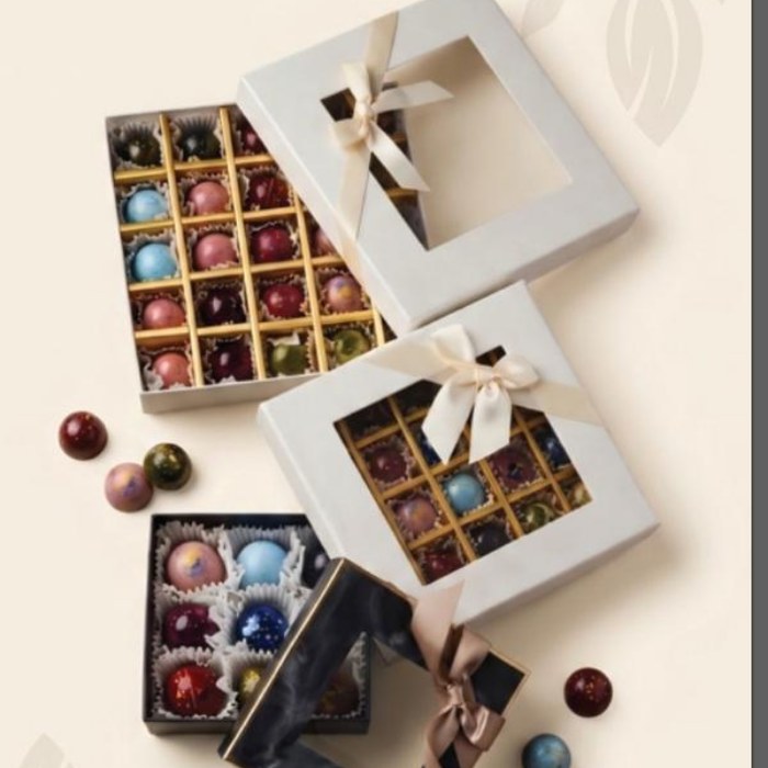 Three Louvion boxes, open, filled with marbled bonbons